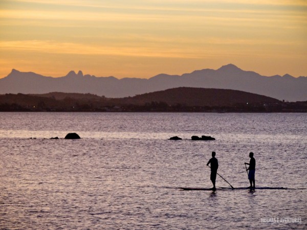 Amigos andando de SUP em Manguinhos durante o pôr-do-sol