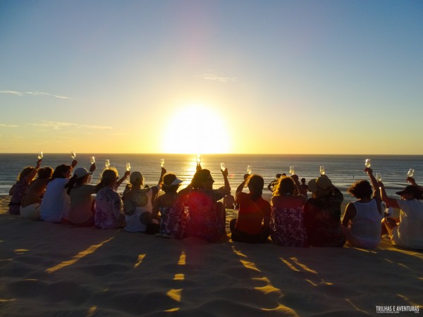 Grupo de amigas brindando ao pôr-do-sol em Jericoacoara