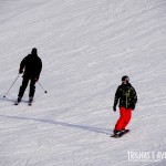 Esquiador e snowboarder descendo juntos a montanha