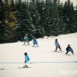 As crianças se amarram nas aulas em grupo das estações de ski