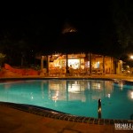 Vista noturna da piscina e restaurante