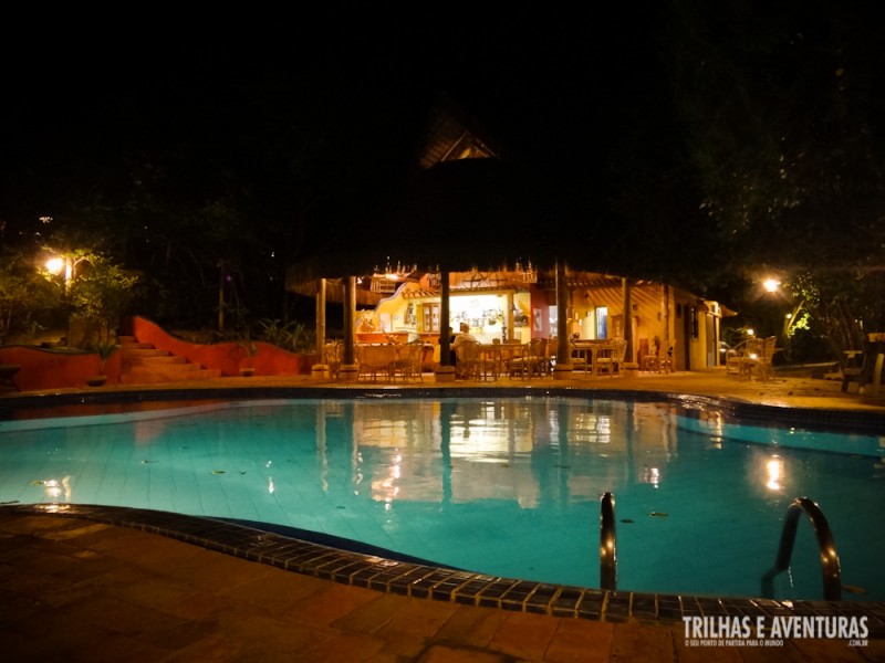 Vista noturna da piscina e restaurante