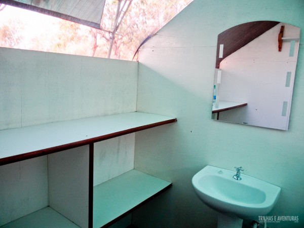 O banheiro da barraca possui espaço para malas, pia, espelho e vaso sanitário